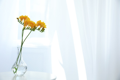 Beautiful yellow freesia flowers on table indoors. Space for text