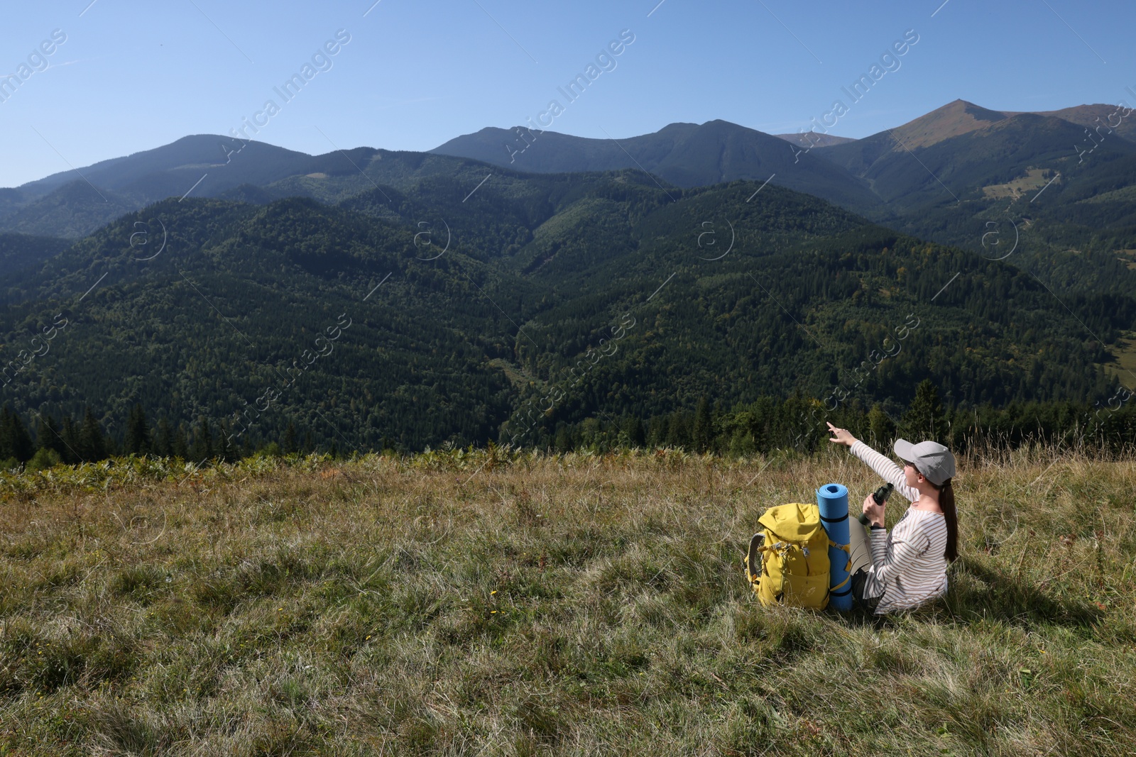 Photo of Tourist with hiking equipment and binoculars in mountains