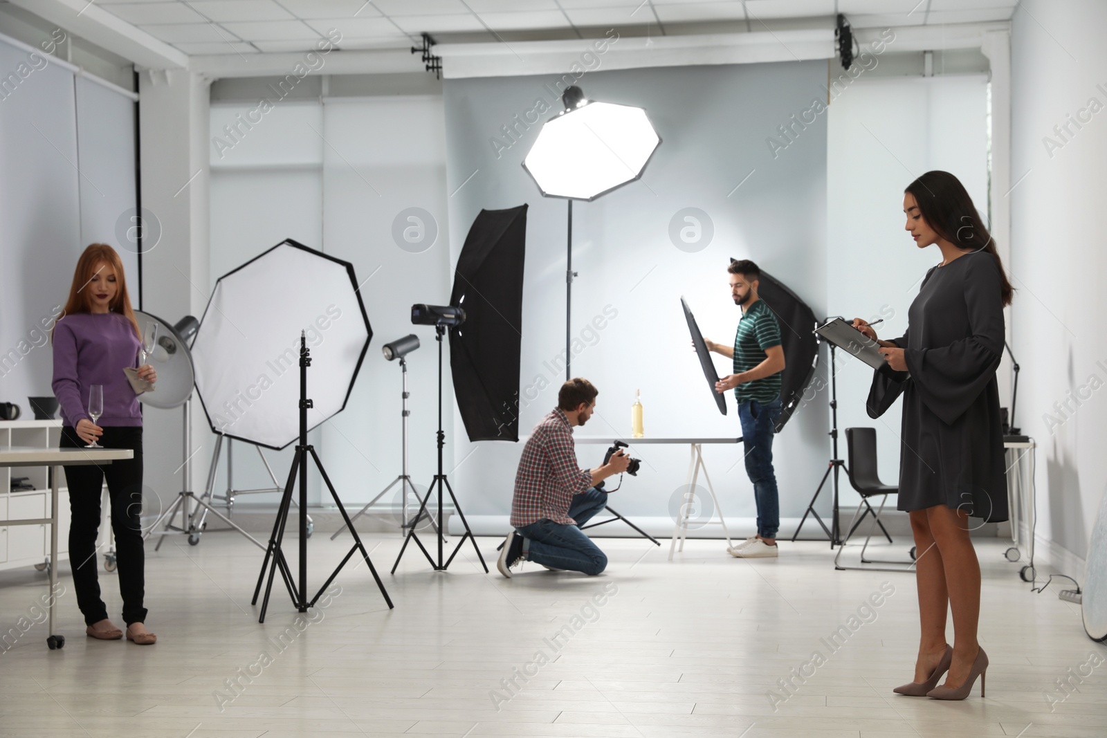 Photo of Photo studio with professional equipment and team of workers