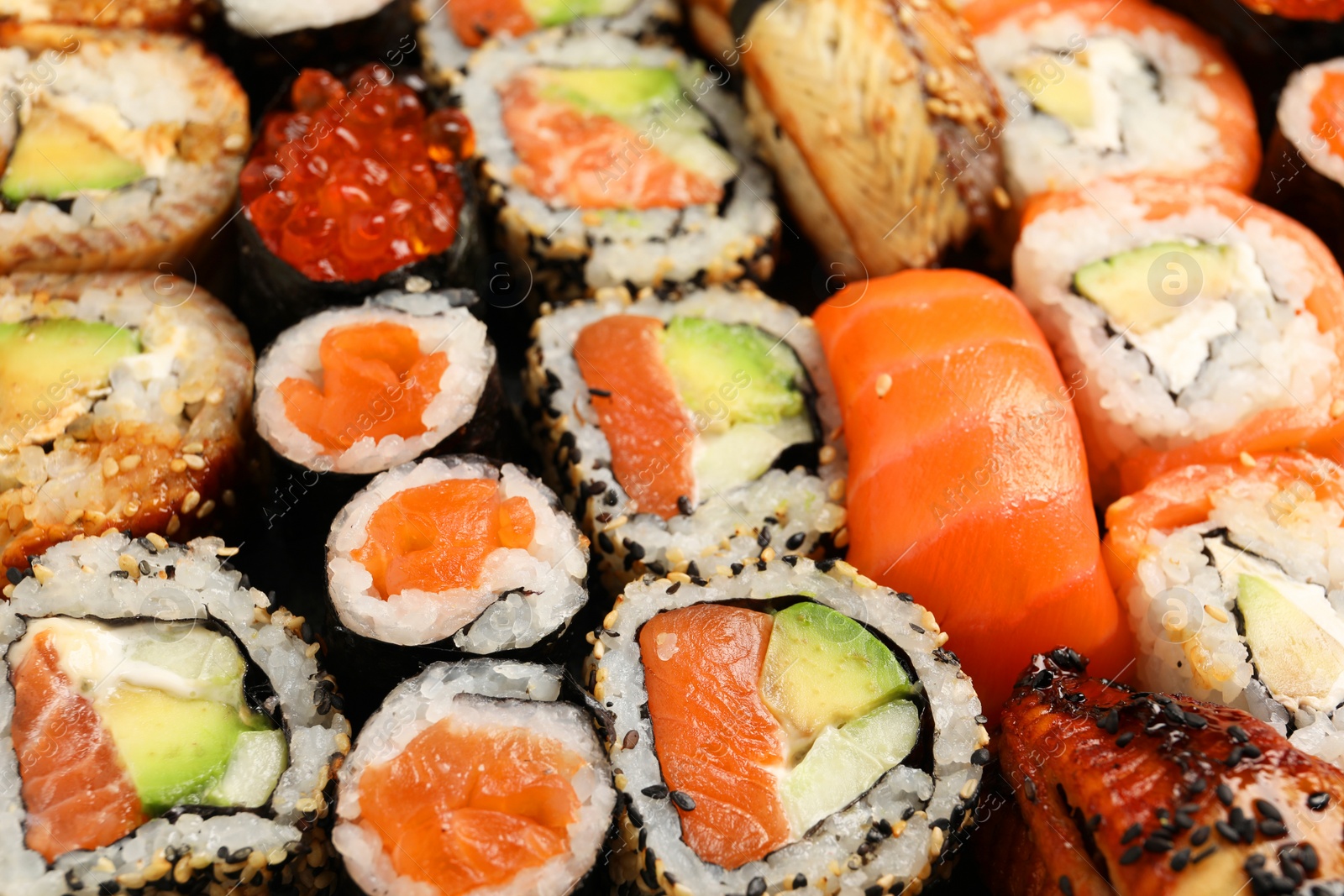 Photo of Different tasty sushi rolls as background, closeup