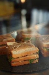 Photo of Showcase with yummy sandwiches in cafe, closeup