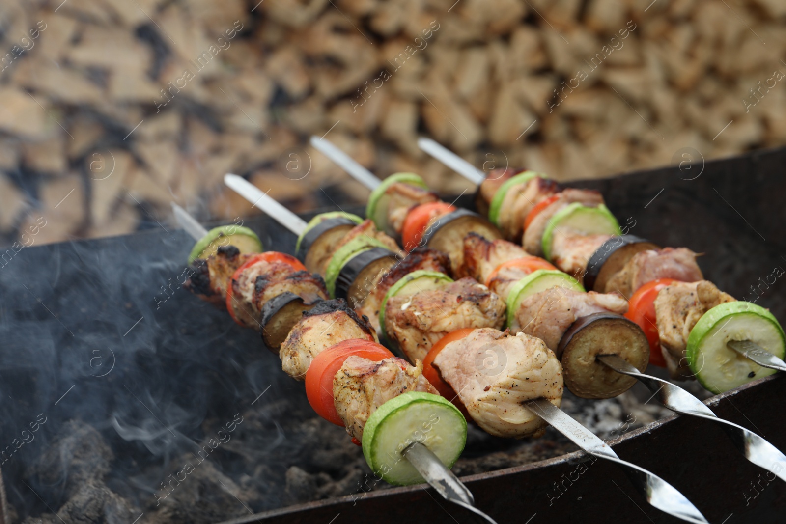 Photo of Cooking meat and vegetables on brazier outdoors