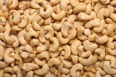 Photo of Many tasty cashew nuts as background, top view