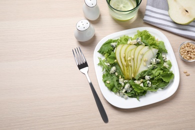 Photo of Fresh salad with pear served on wooden table, flat lay. Space for text
