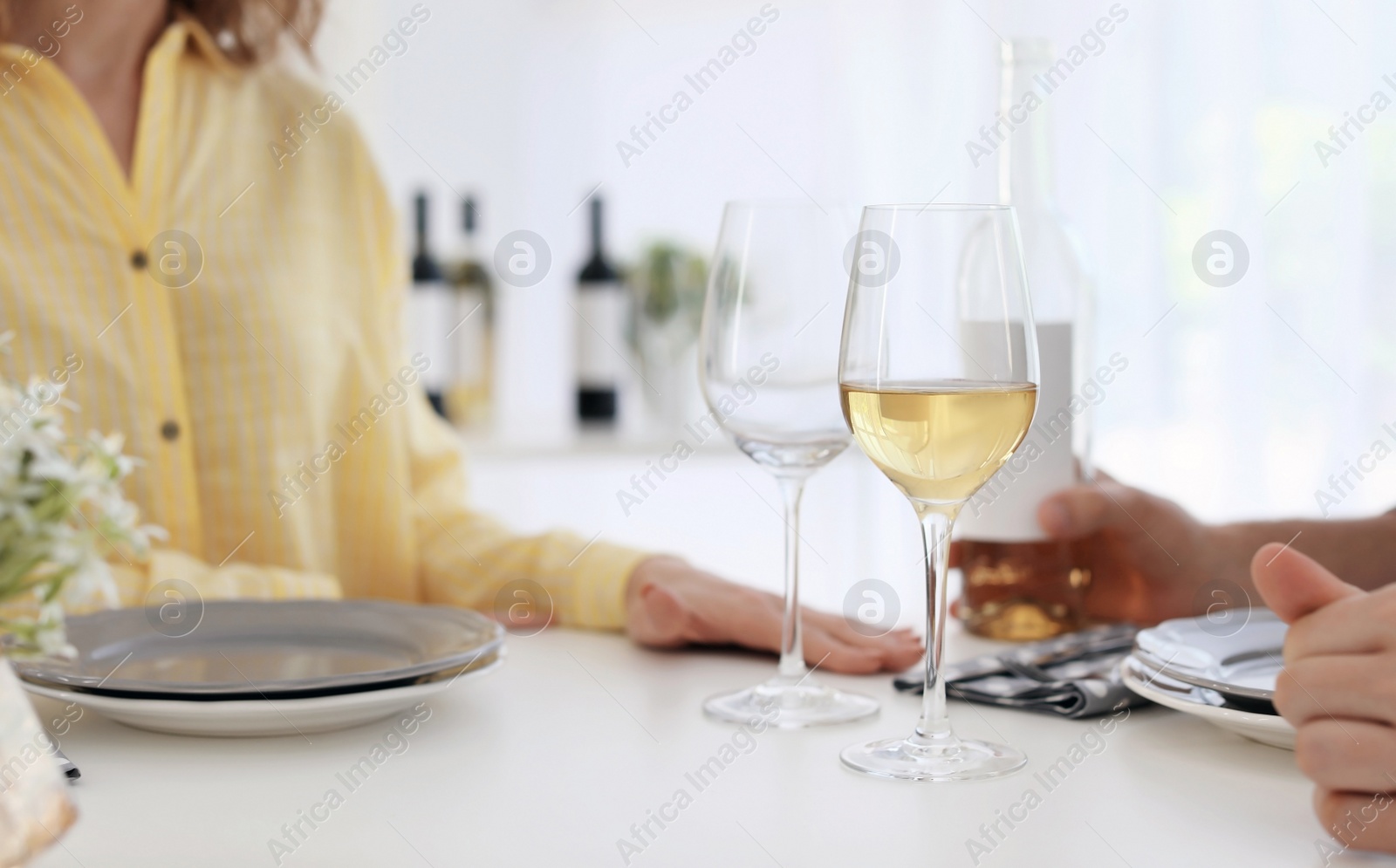 Photo of Young couple with glasses of wine at table in restaurant