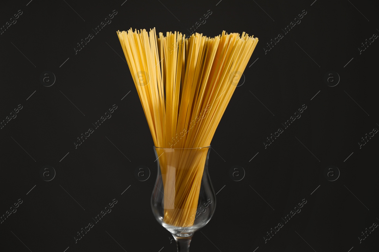 Photo of Uncooked spaghetti on black background, closeup. Italian pasta