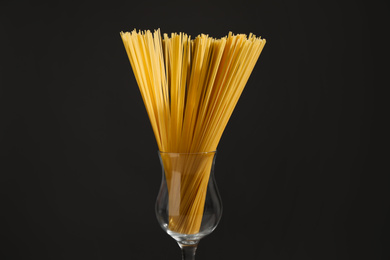 Photo of Uncooked spaghetti on black background, closeup. Italian pasta