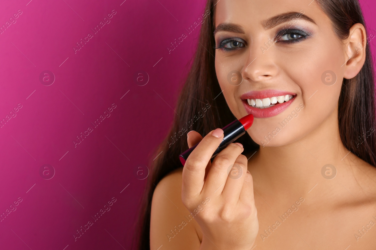 Photo of Portrait of beautiful woman with lipstick and space for text on color background. Stylish makeup