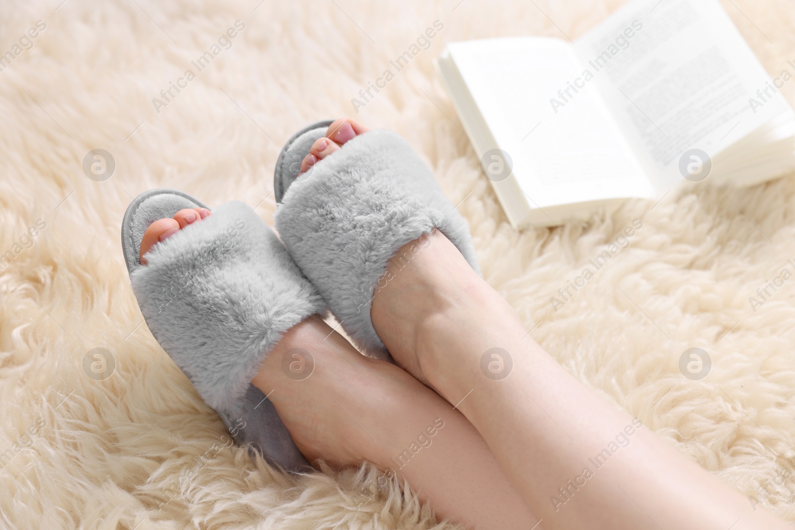 Photo of Woman in grey soft slippers at home, closeup