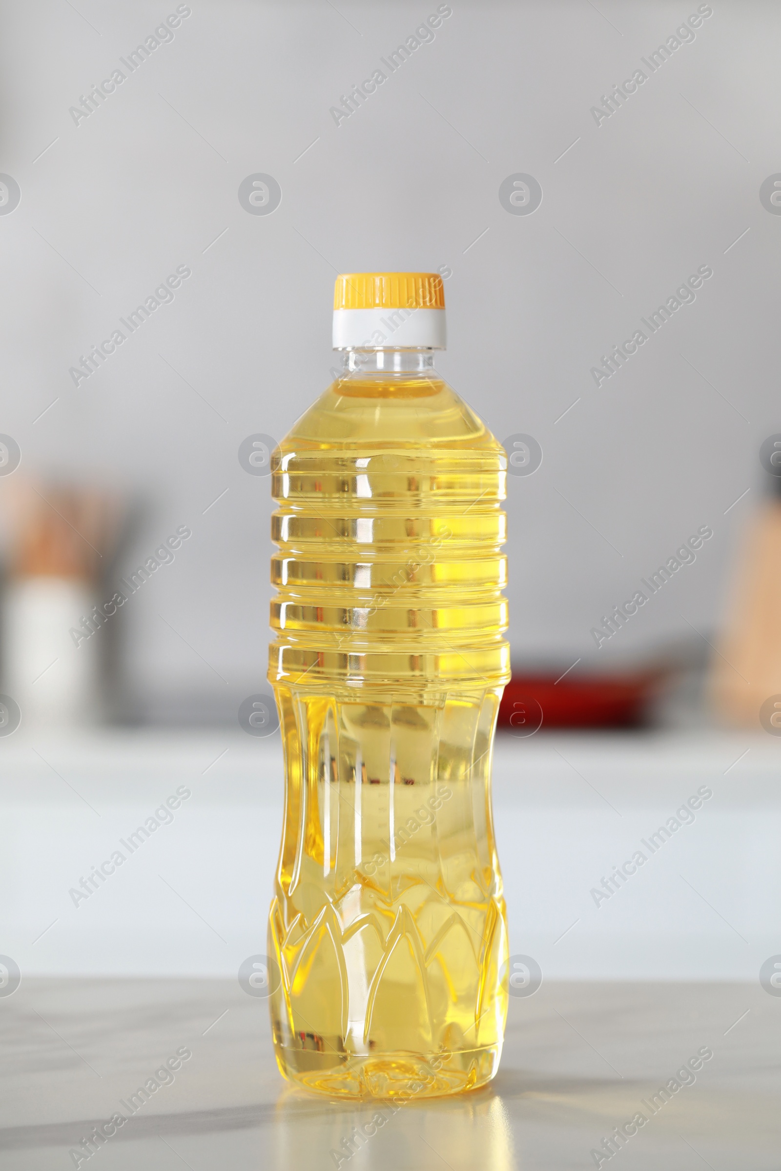 Photo of Bottle of cooking oil on white marble table in kitchen