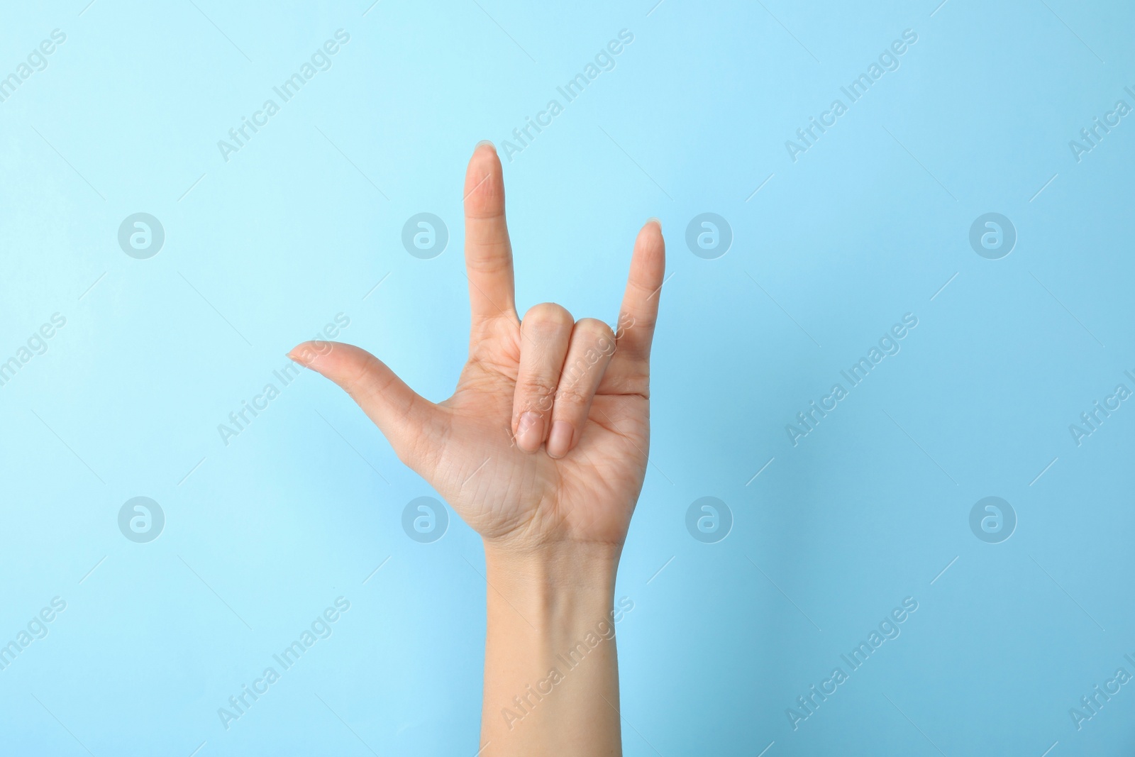 Photo of Woman showing hand sign on color background, closeup. Body language