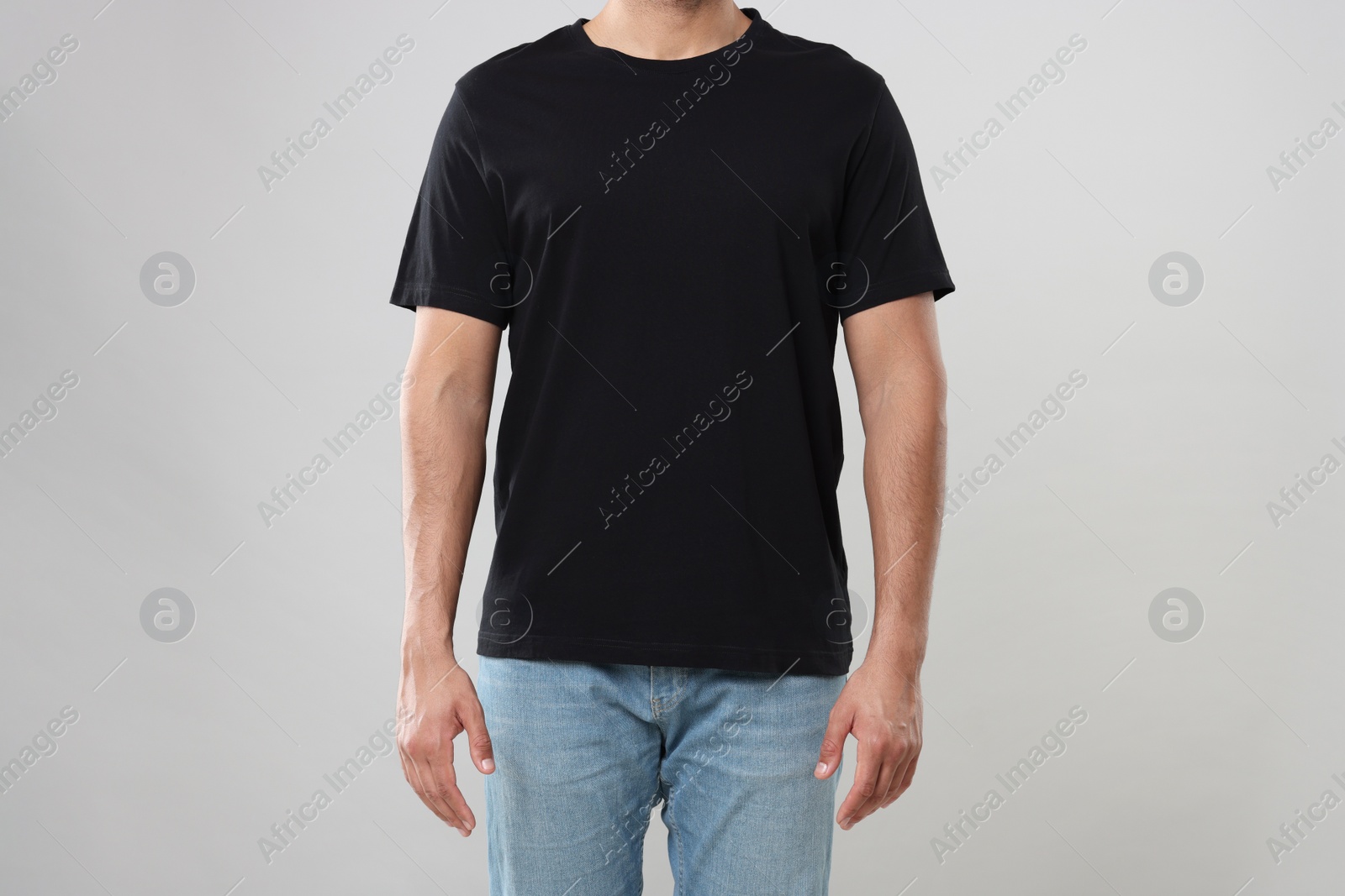 Photo of Man wearing black t-shirt on gray background, closeup