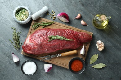 Photo of Piece of raw beef meat and spices on grey table, flat lay