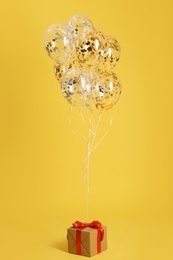 Photo of Bright balloons and gift box on color background