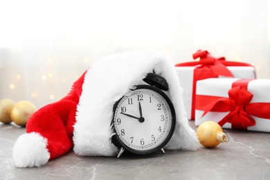 Photo of Alarm clock and Santa hat on table. Christmas countdown