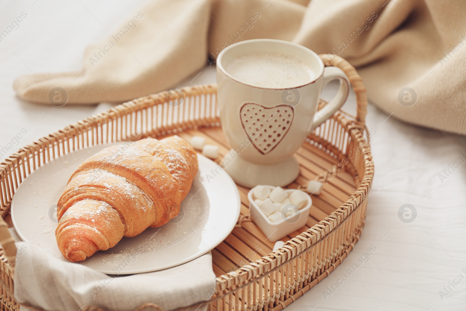 Photo of Delicious morning coffee and croissant on bed