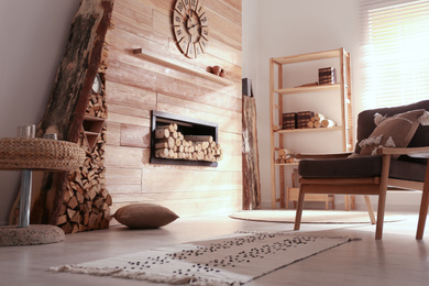 Photo of Decorative fireplace with stacked wood in cozy living room interior