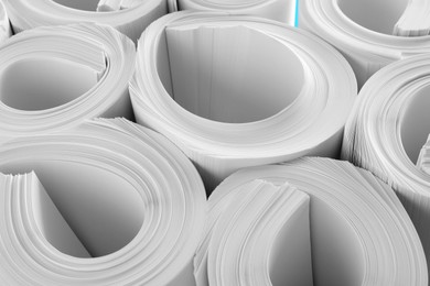 Photo of Rolled white paper sheets as background, closeup