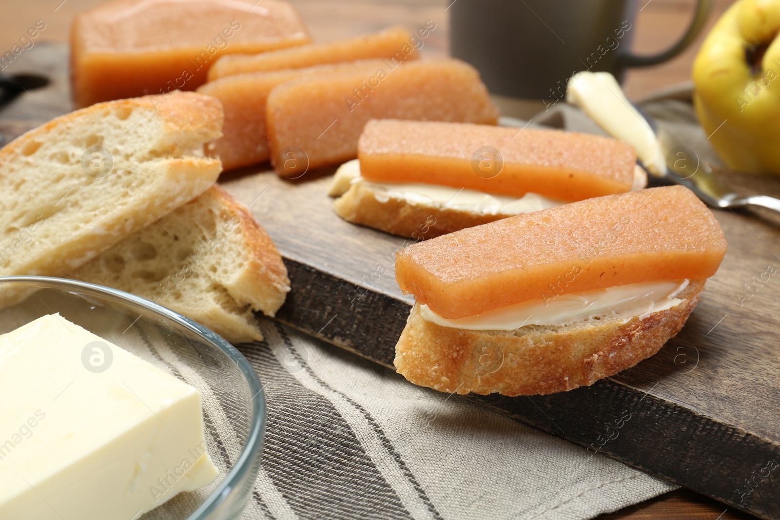 Photo of Quince paste sandwiches and fresh fruit on table, closeup