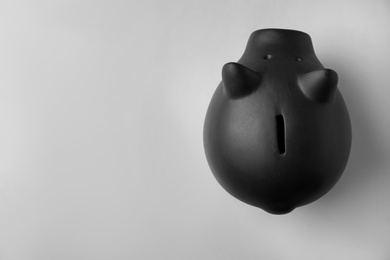 Photo of Black piggy bank on gray background, top view