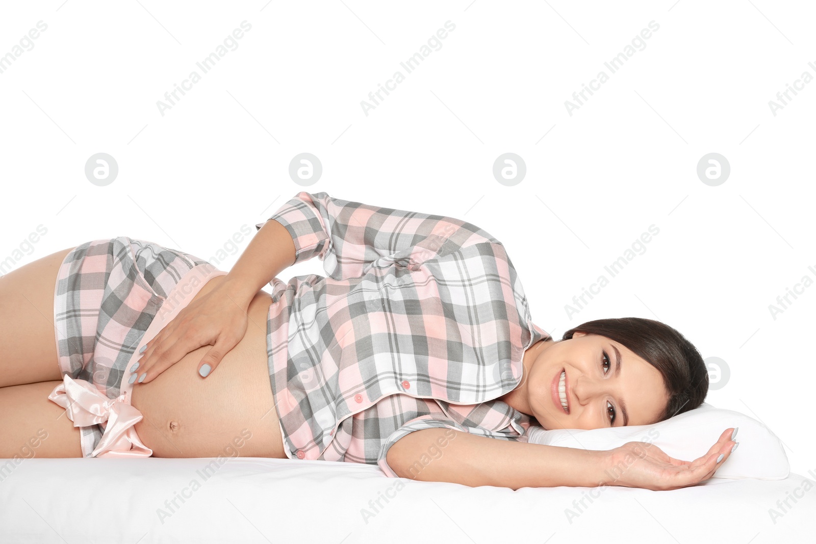 Photo of Beautiful pregnant woman lying with orthopedic pillow on bed against white background