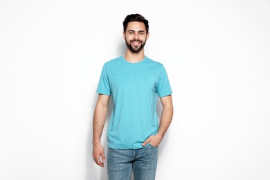 Photo of Young man in t-shirt on light background. Mock up for design