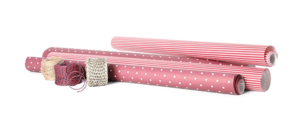 Photo of Different colorful wrapping paper rolls and ropes on white background