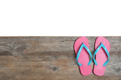 Photo of Pair of pink flip flops and space for text on wooden table against white background, top view