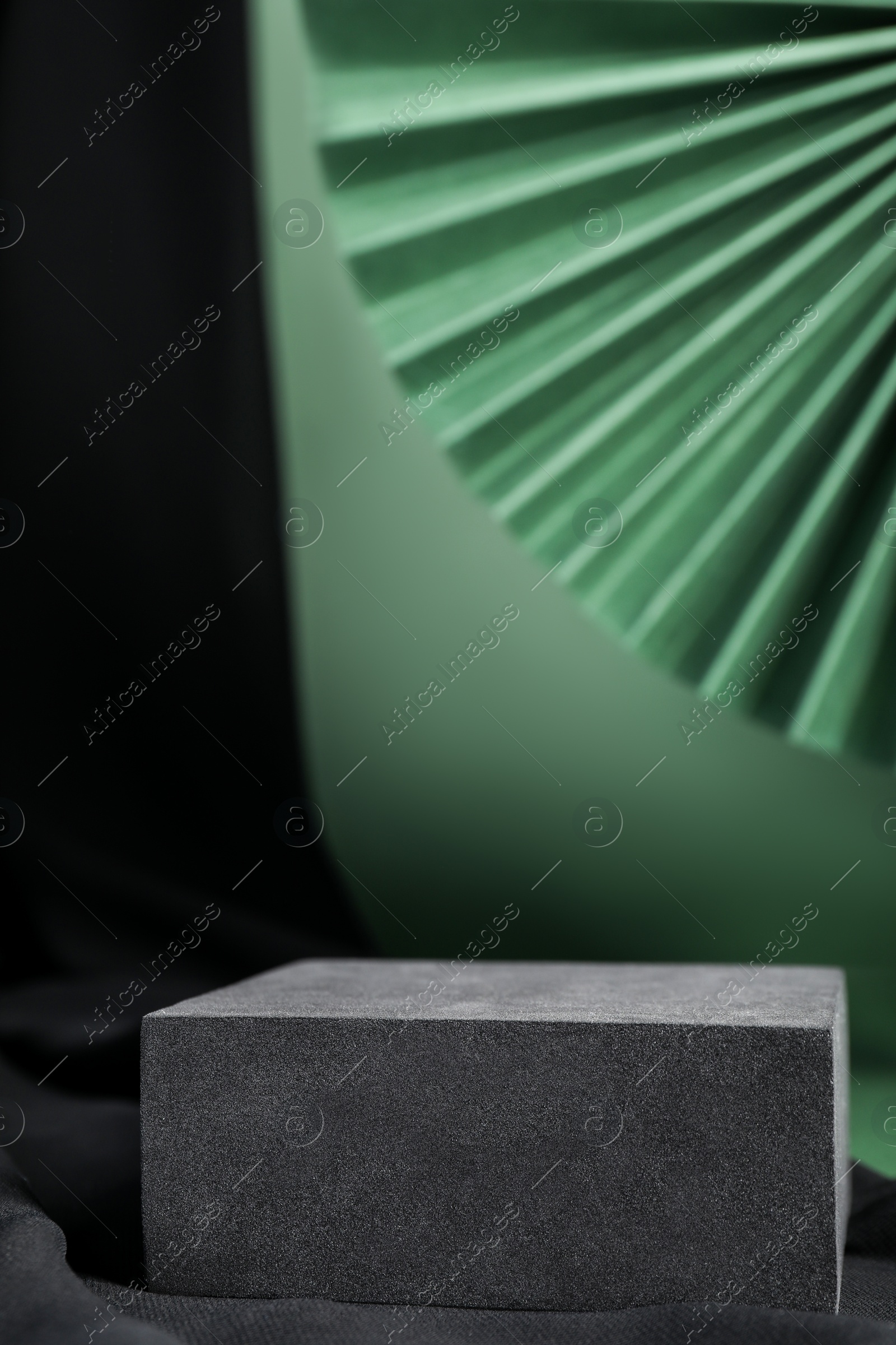 Photo of Black stand on green background, space for text. Stylish presentation for product