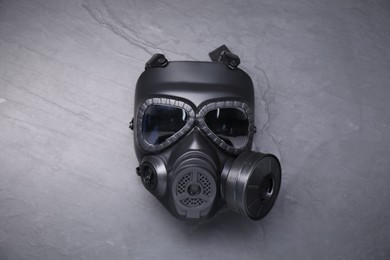 One gas mask on grey textured background, top view