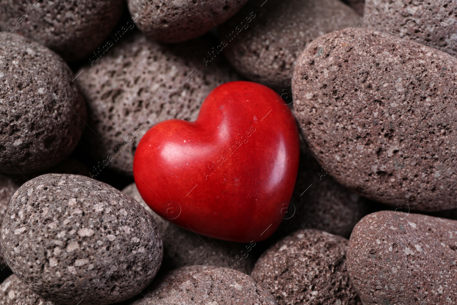 Photo of One red decorative heart on stones, above view