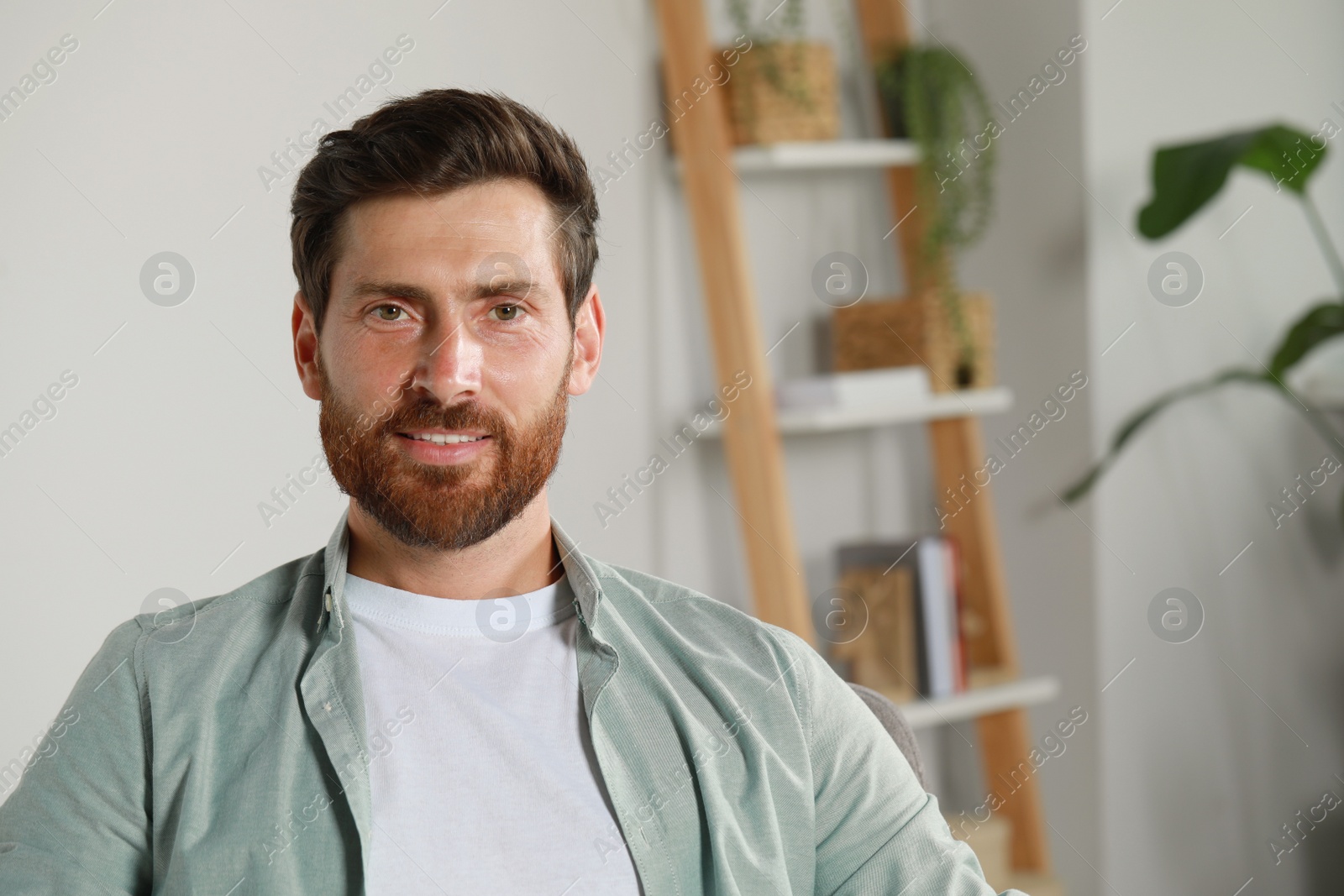 Photo of Portrait of handsome bearded man at home, space for text