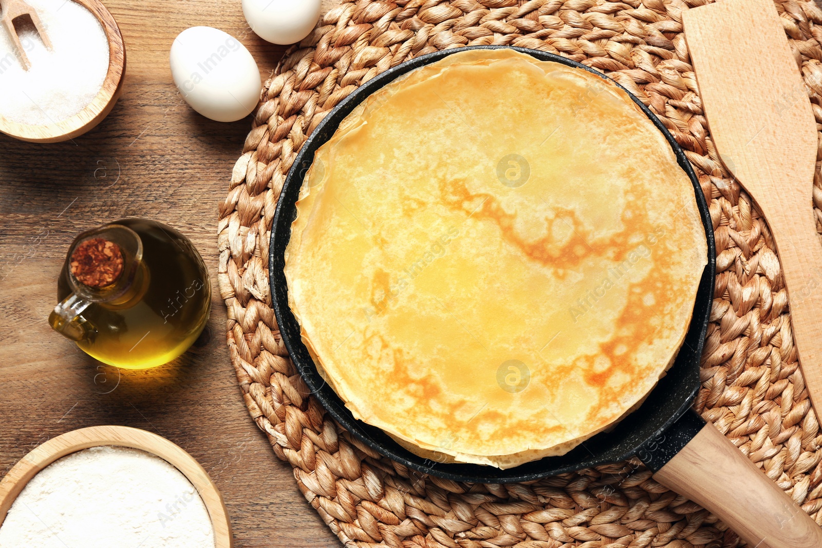 Photo of Delicious crepes and ingredients on wooden table, flat lay