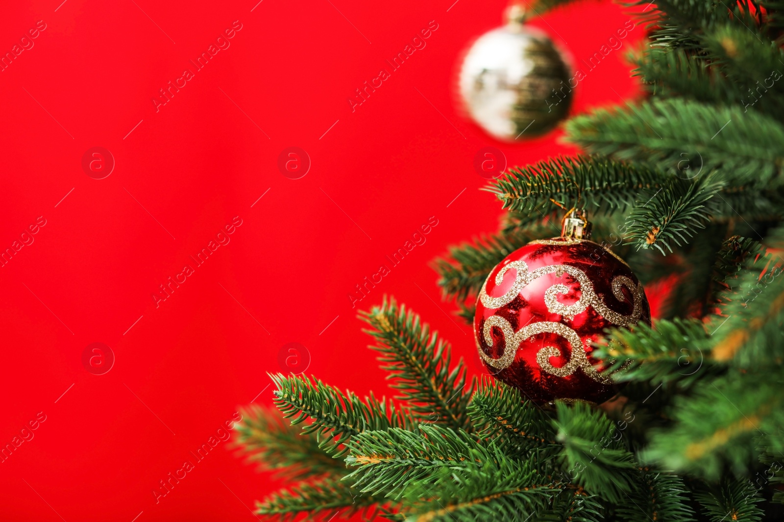 Photo of Beautifully decorated Christmas tree against color background, closeup