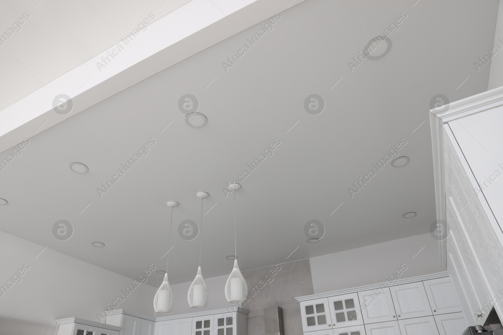 Photo of Ceiling with modern lamps and furniture in stylish kitchen, low angle view