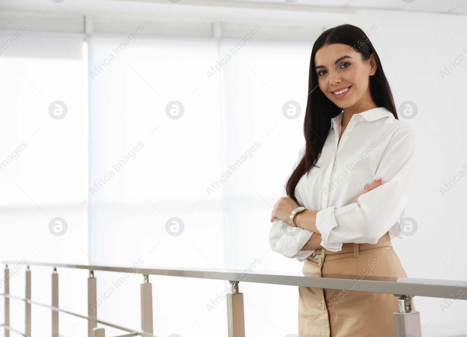 Photo of Happy young businesswoman leaning on railing in office. Space for text