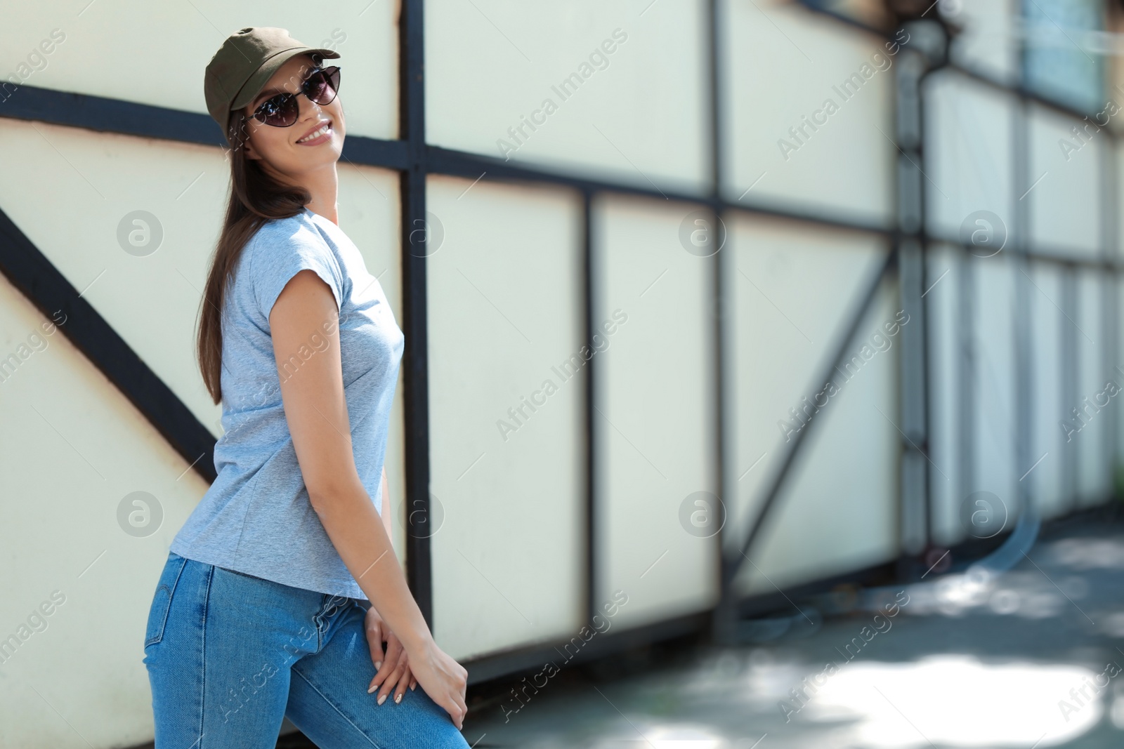 Photo of Young woman wearing gray t-shirt on street. Urban style