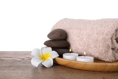 Photo of Tray with candles and spa supplies on wooden table against white background