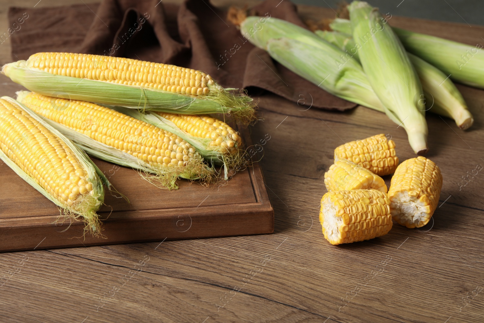 Photo of Tasty sweet corn cobs on wooden table