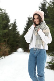 Young woman in snowy conifer forest. Winter vacation