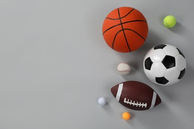 Many different sports balls on gray background, flat lay. Space for text