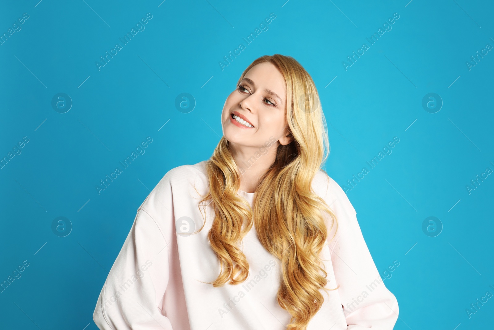 Photo of Portrait of beautiful young woman with dyed long hair on blue background