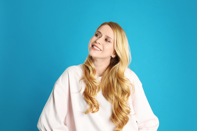 Photo of Portrait of beautiful young woman with dyed long hair on blue background