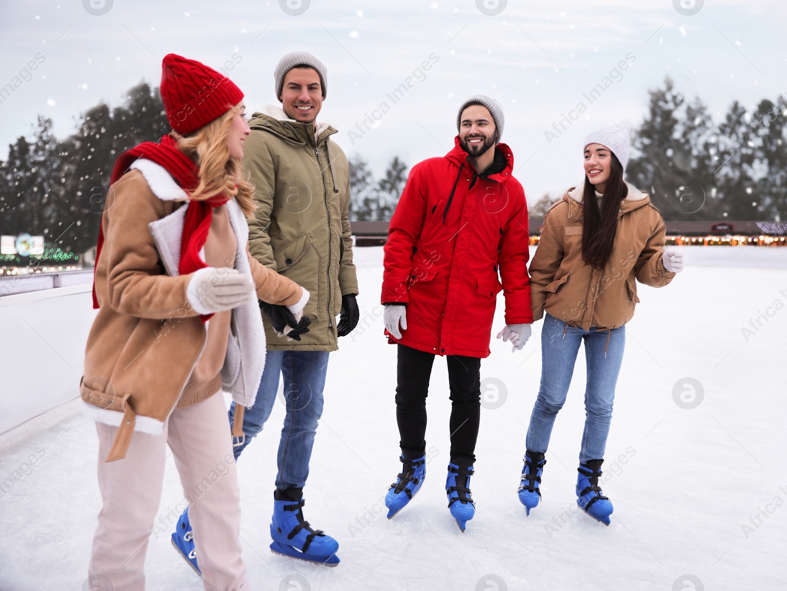 Image of Group of friends skating at outdoor ice rink