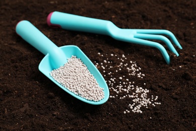 Photo of Gardening tools and chemical fertilizer on soil