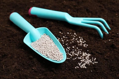 Gardening tools and chemical fertilizer on soil