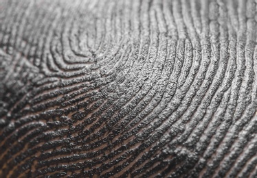 Closeup view of human finger covered with black ink