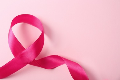 Pink ribbon and space for text on color background. Breast cancer awareness concept