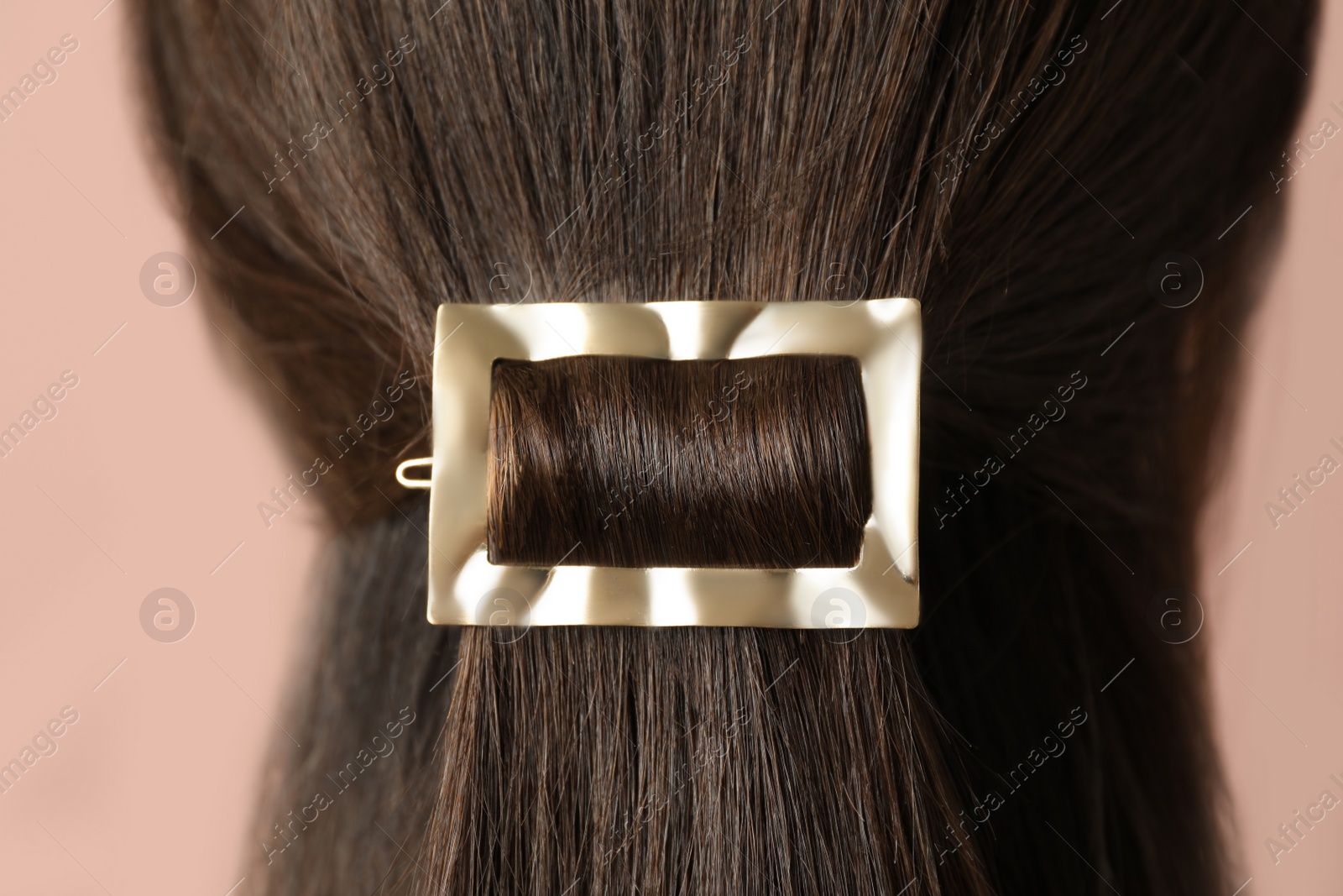 Photo of Young woman with beautiful gold hair clip on pink background, closeup