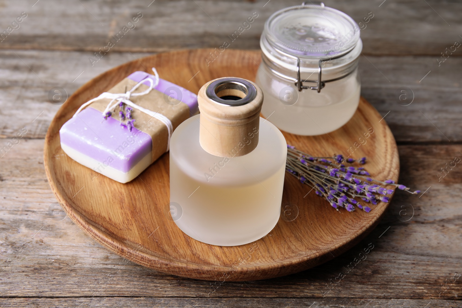 Photo of Natural herbal oil, soap and lavender flowers on wooden background